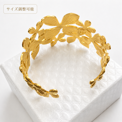 「XINXINIO」 手元に咲く 金色の花 フフラワーモチーフ ゴールドバングル 立体感のあるデザイン